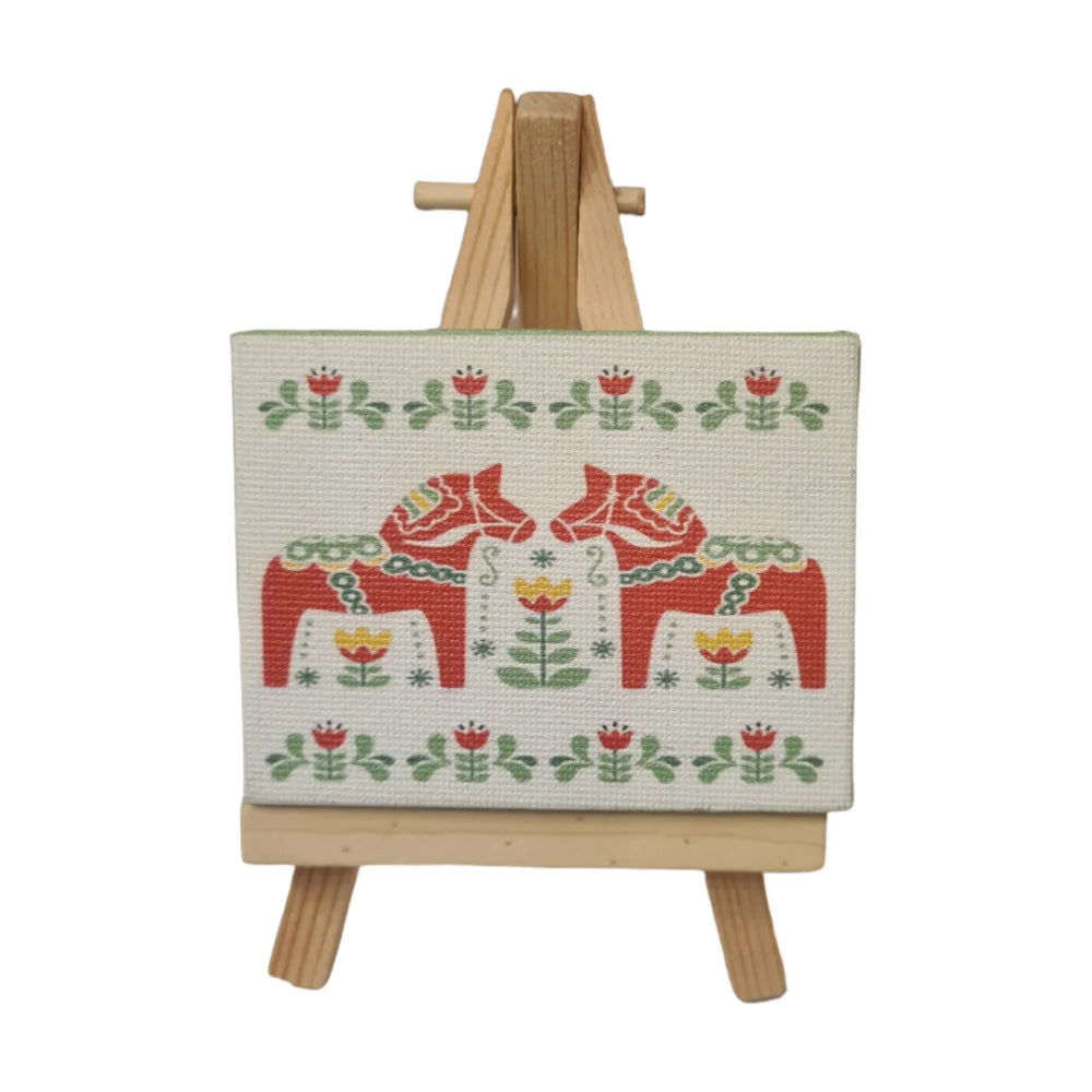 Swedish Dala horse decor featuring traditional red and green designs on a canvas with an easel