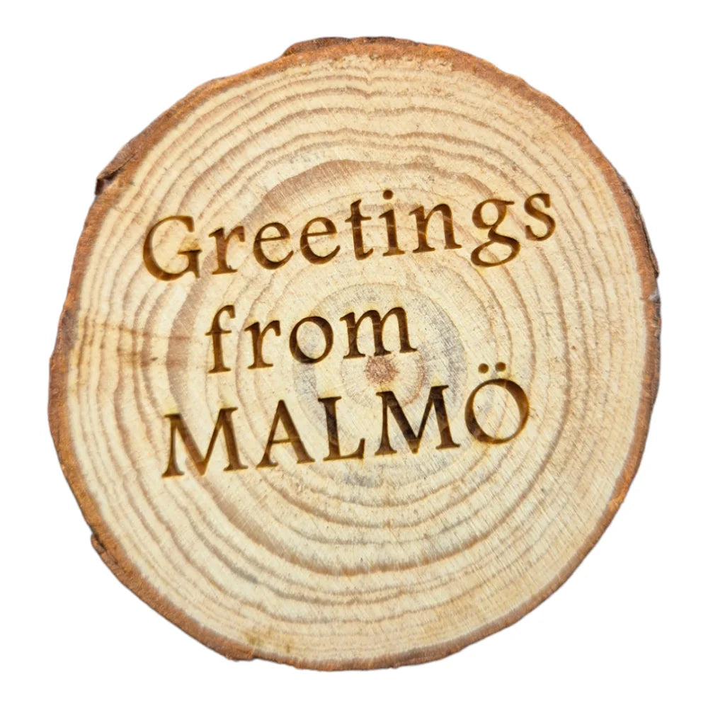 Wooden fridge magnet featuring engraved greetings from Malmo on a rustic wood slice